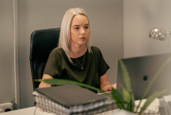 Sharon Starkey, lady sat at desk with blonde hair.
