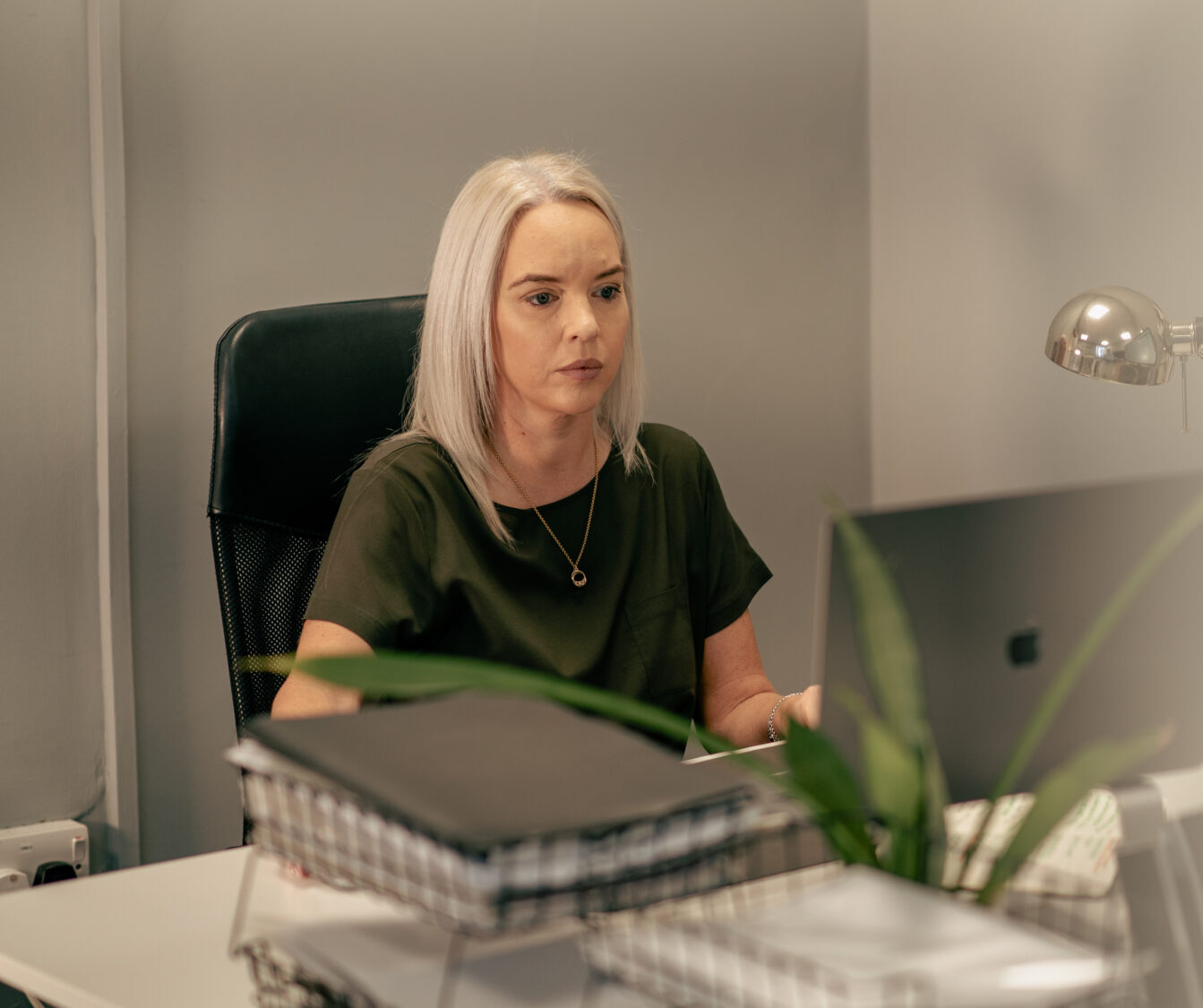 Sharon Starkey, lady sat at desk with blonde hair.